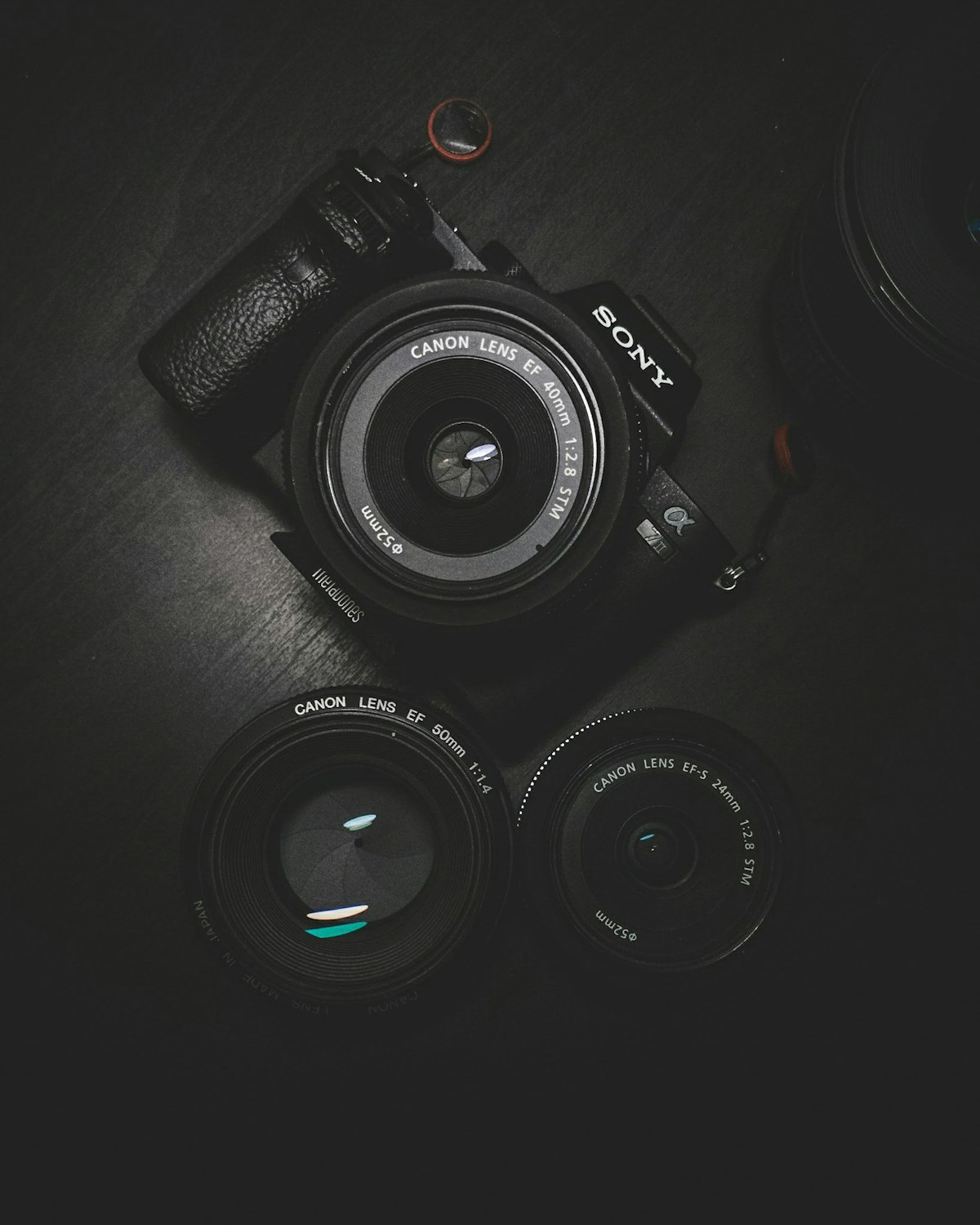 Camera and lenses on a dark desk