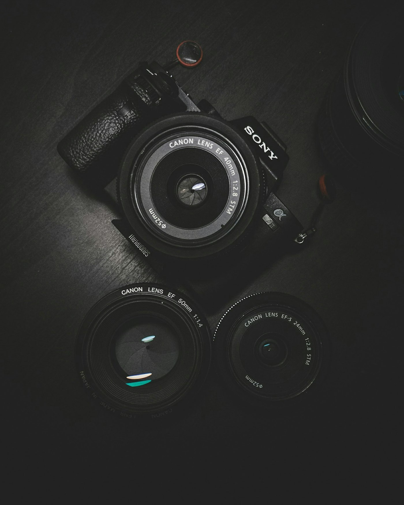 Camera body and lenses laid out on a dark table